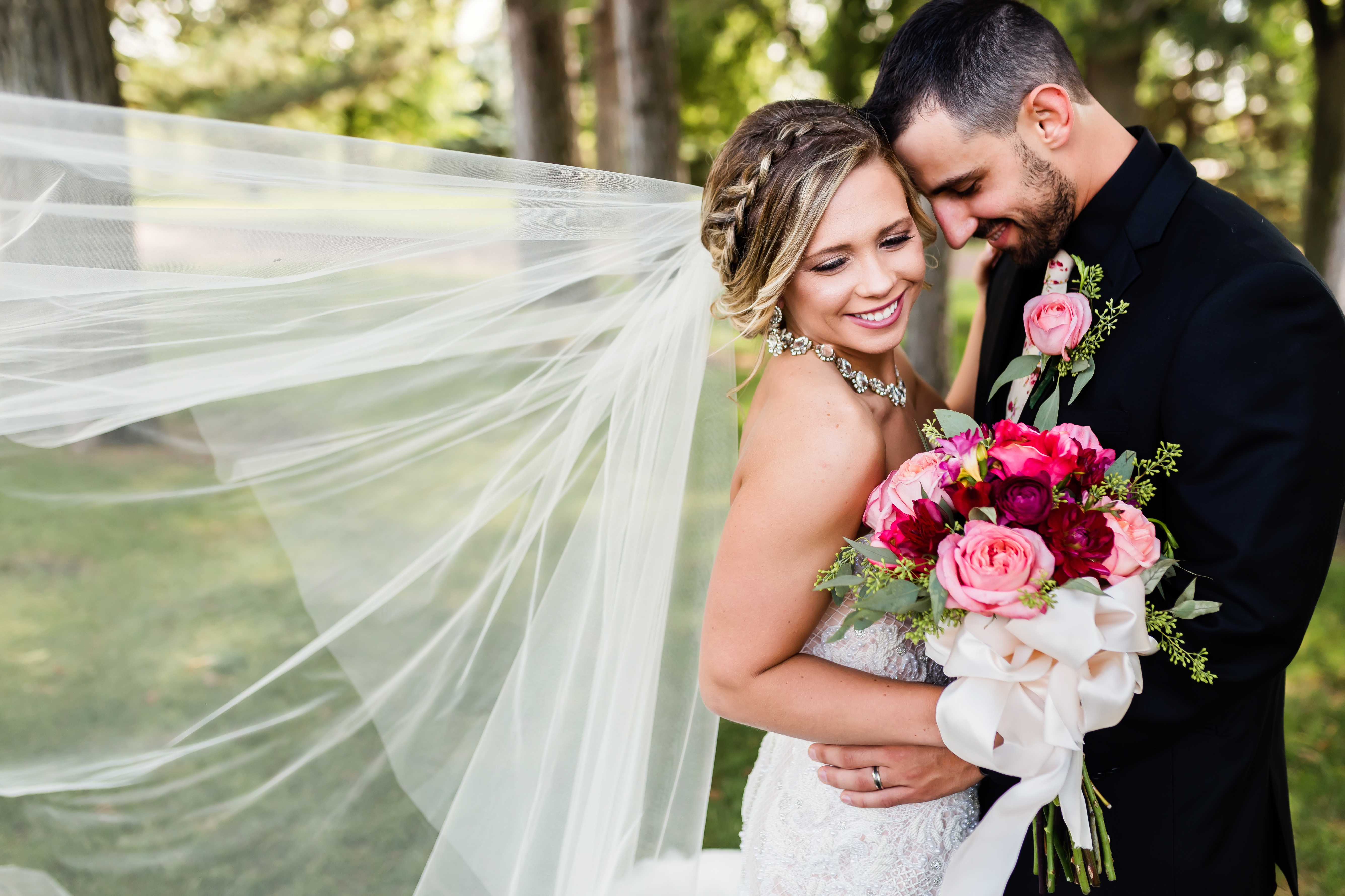 bride and groom embracing with flowing veil