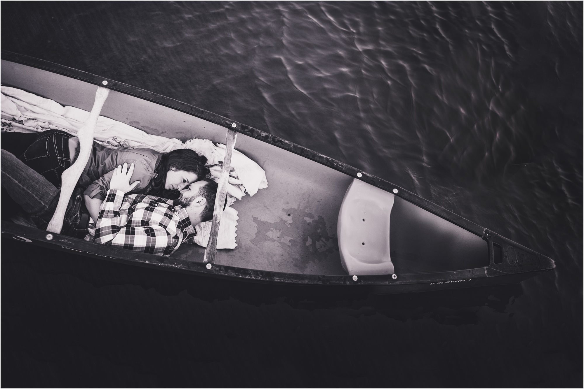 romantic couple laying in a canoe