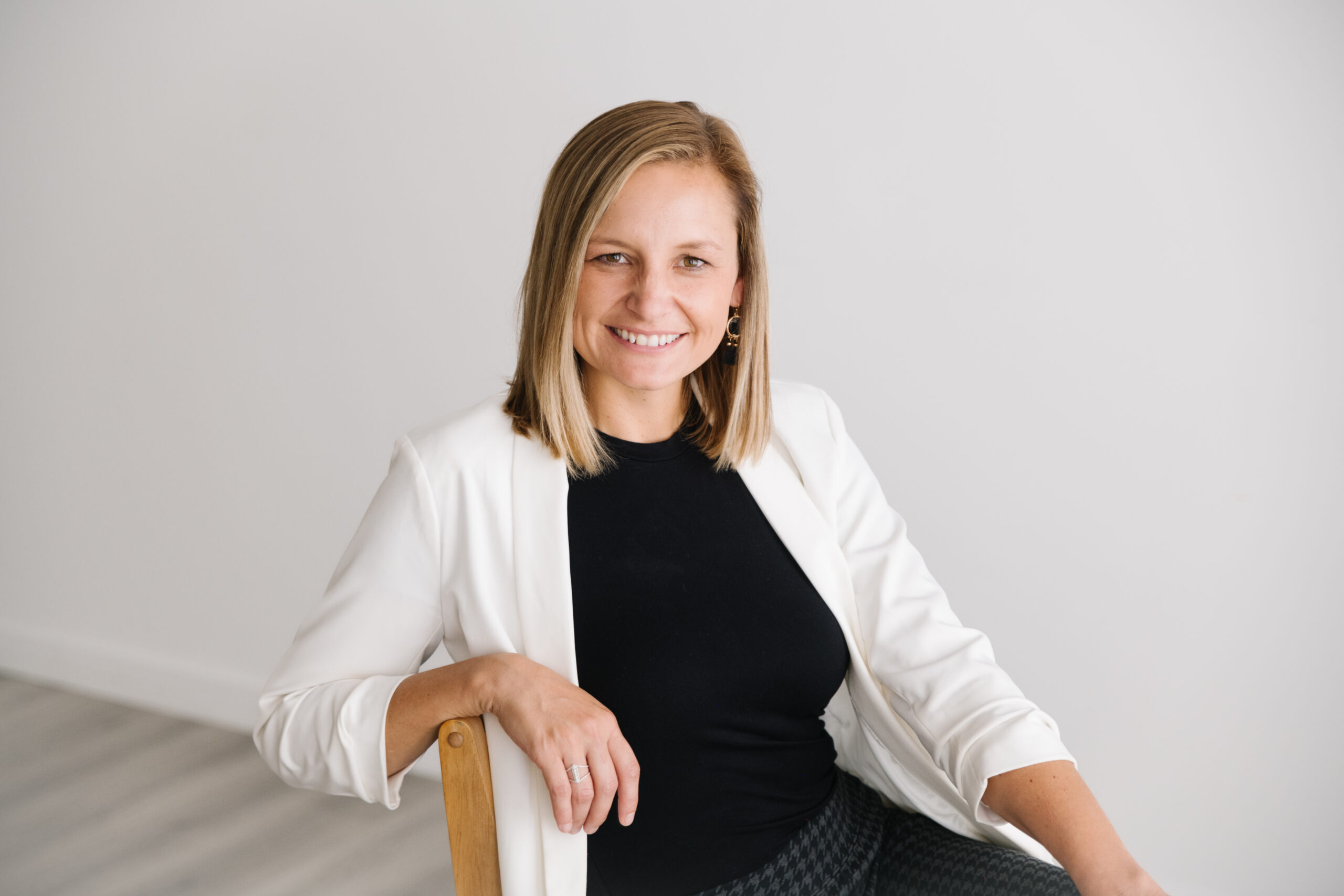 headshot of woman with shoulder length blonde hair sitting on stool