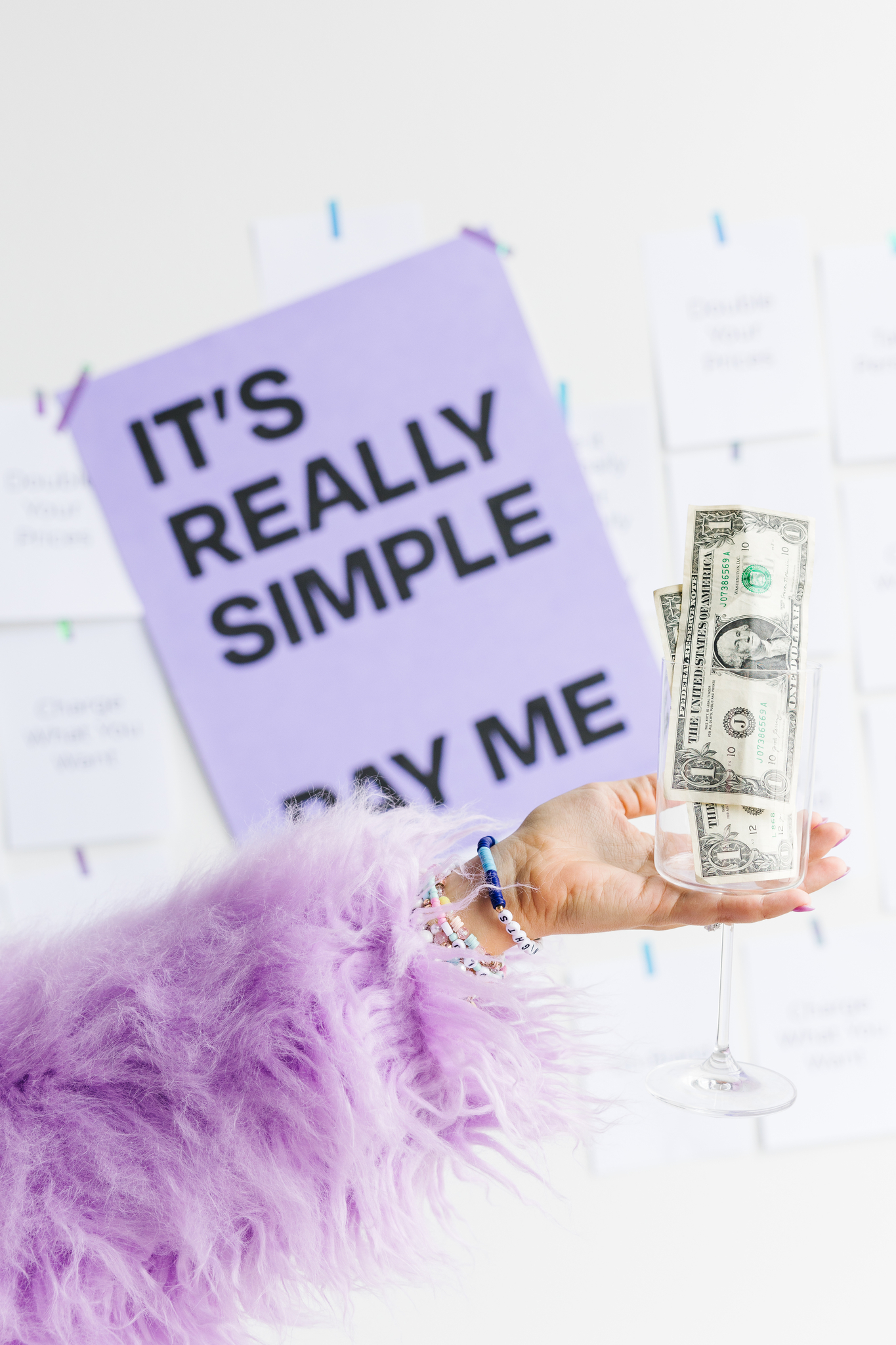 Maddie holding cup with money for Charge More, Stress Less promotion