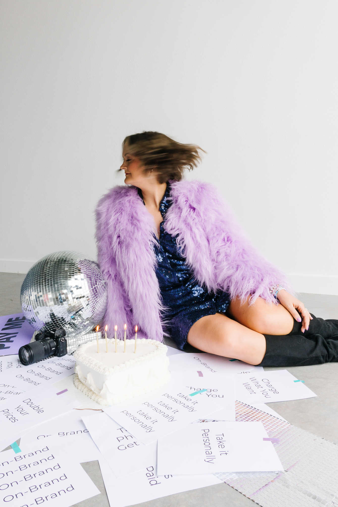 Maddie in purple coat in photography studio tossing hair aesthetics