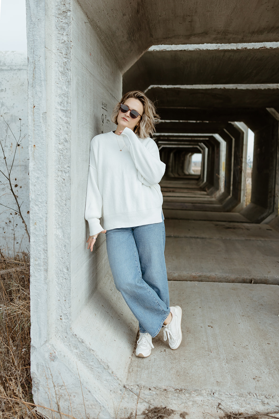 Maddie brand photographer standing in tunnel posing for Instagram photo